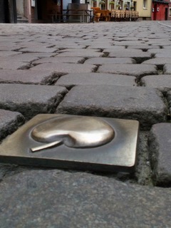 Calle de adoquines con manzana en placa dorada en Sachsenhausen, Frankfurt